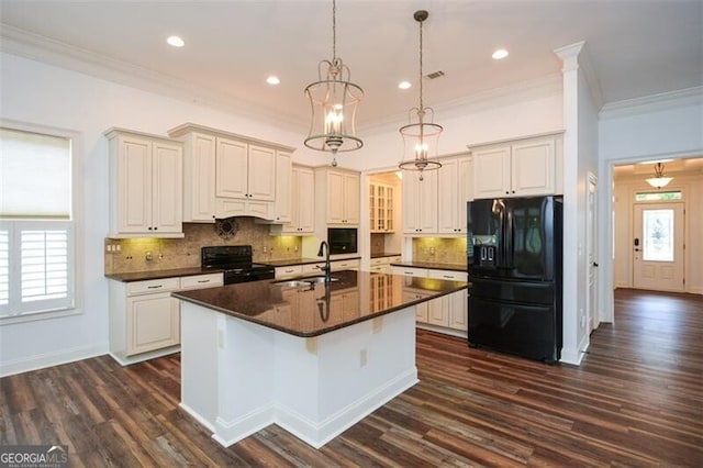 kitchen with black appliances, plenty of natural light, a center island with sink, and sink