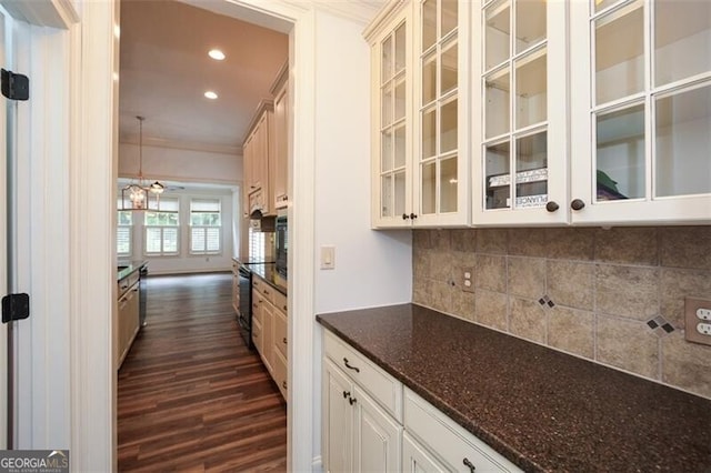 bar with white cabinetry, dark wood-type flooring, dark stone counters, pendant lighting, and ornamental molding