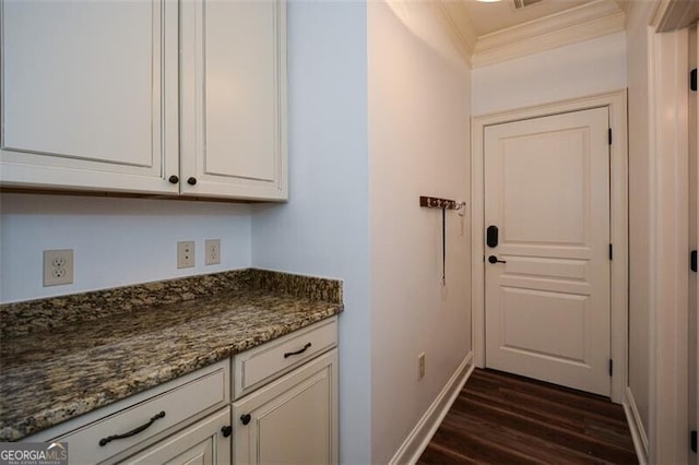 interior space featuring ornamental molding and dark wood-type flooring