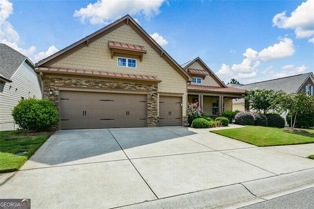 craftsman inspired home with a garage and a front yard