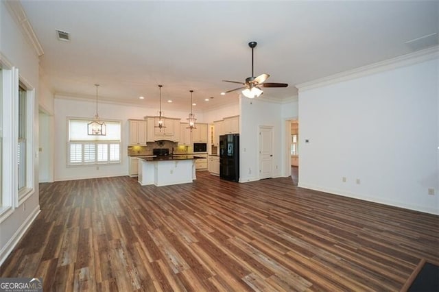 kitchen with white cabinetry, black fridge, dark hardwood / wood-style flooring, and a center island