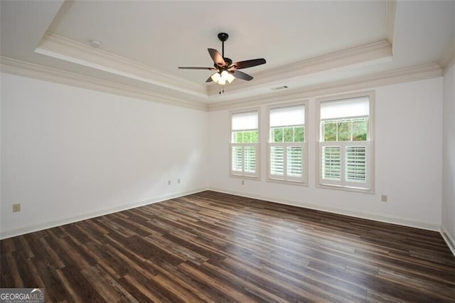 unfurnished room featuring dark hardwood / wood-style flooring, a raised ceiling, ceiling fan, and ornamental molding