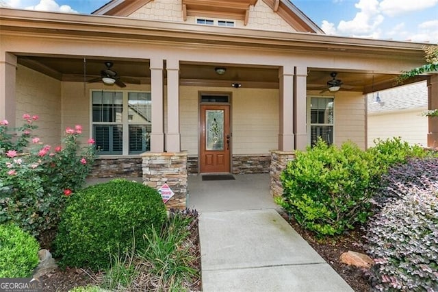 view of exterior entry featuring ceiling fan and a porch