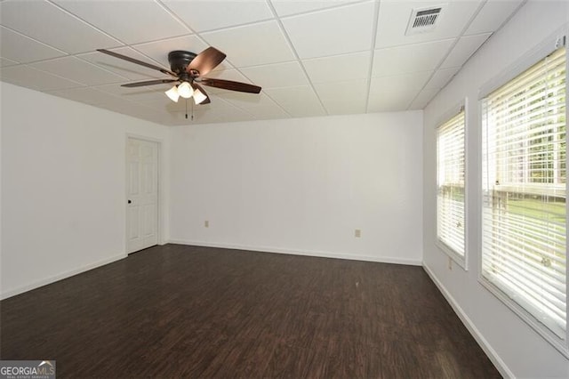 unfurnished room with a drop ceiling, dark wood-type flooring, and ceiling fan