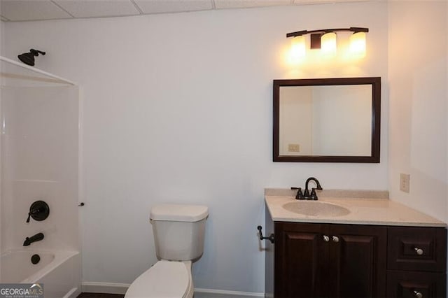 full bathroom with a paneled ceiling, vanity, bathtub / shower combination, and toilet