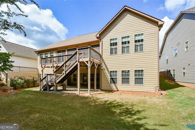 rear view of house with a lawn and a wooden deck