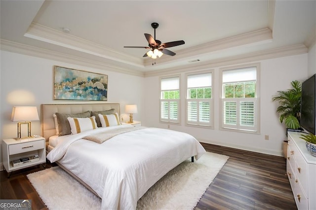 bedroom featuring dark hardwood / wood-style floors, a raised ceiling, and ceiling fan