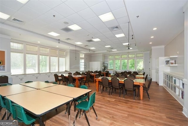 dining space featuring a paneled ceiling, light hardwood / wood-style floors, and a wealth of natural light