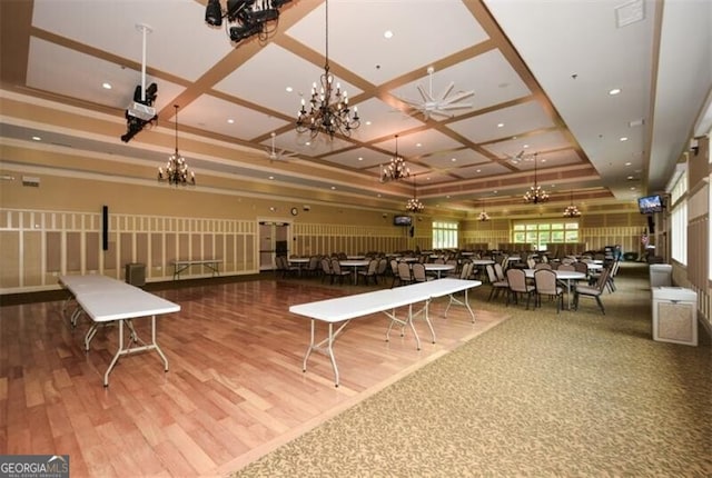 dining space with beam ceiling, a chandelier, wood-type flooring, and coffered ceiling