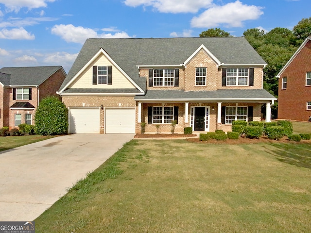 view of front facade with a garage, a front lawn, and covered porch