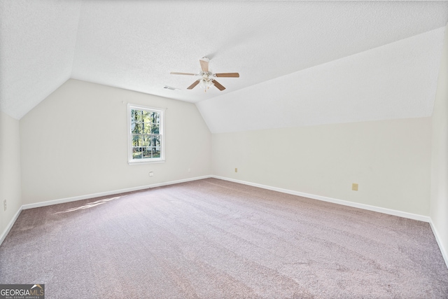 bonus room with lofted ceiling, a textured ceiling, carpet floors, and ceiling fan