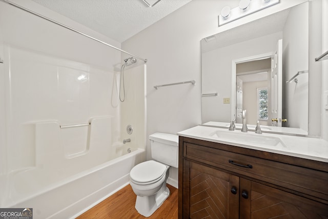 full bathroom with toilet, shower / bathtub combination, hardwood / wood-style floors, vanity, and a textured ceiling