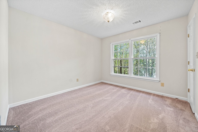 carpeted spare room featuring a textured ceiling