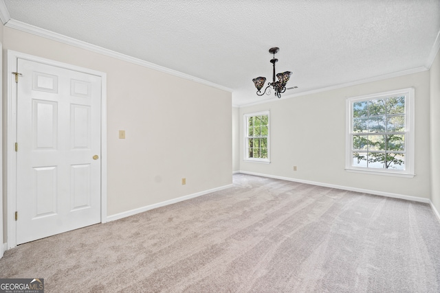 carpeted empty room featuring ornamental molding, a notable chandelier, and a textured ceiling