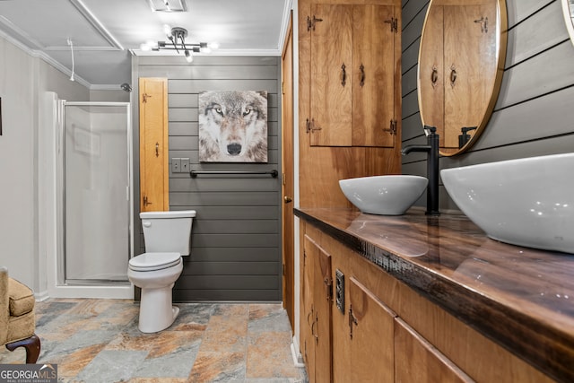 bathroom featuring ornamental molding, vanity, a shower with shower door, and toilet