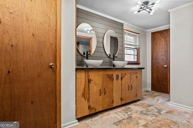 bathroom featuring vanity, wood walls, ornamental molding, and an inviting chandelier