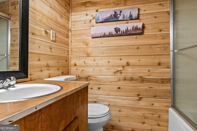 full bathroom featuring vanity, toilet, wooden walls, and enclosed tub / shower combo