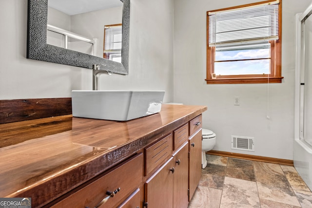 bathroom with vanity, toilet, and a shower with shower door