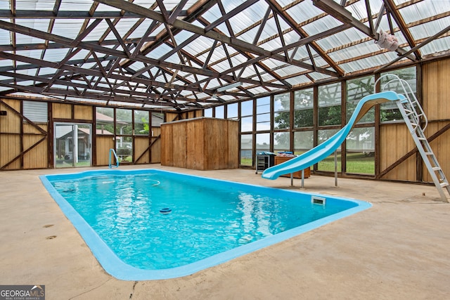 view of swimming pool with a water slide and a patio