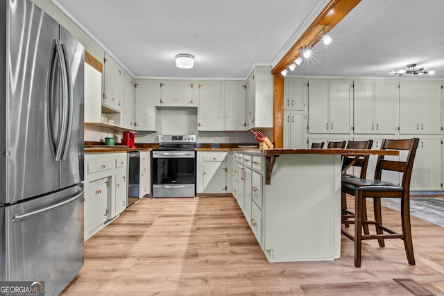 kitchen with a kitchen bar, white cabinets, light hardwood / wood-style floors, and appliances with stainless steel finishes