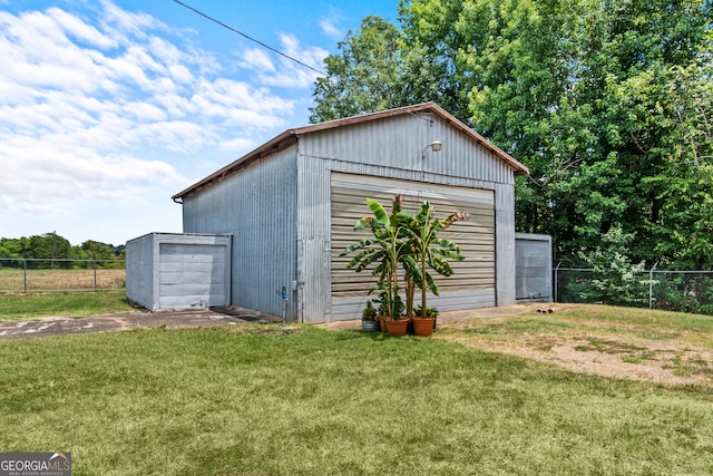 view of outbuilding with a garage and a lawn