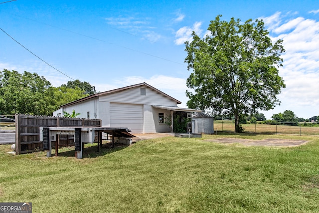 rear view of property with an outbuilding and a yard