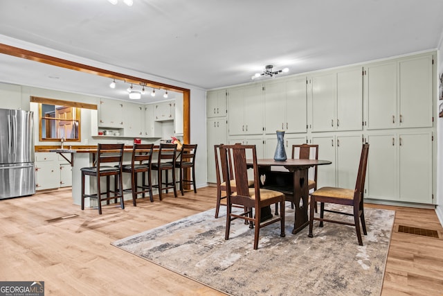 dining area with light wood-type flooring and sink