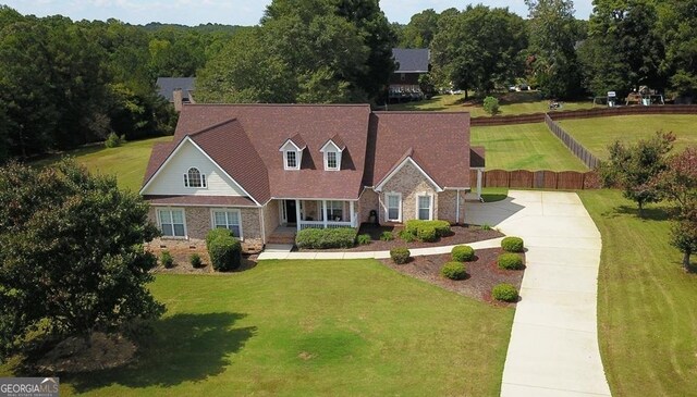 cape cod house featuring a front yard