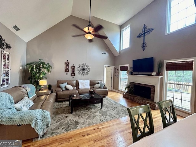 living room with hardwood / wood-style floors, a fireplace, a healthy amount of sunlight, and ceiling fan