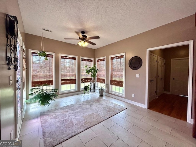 interior space featuring ceiling fan and a textured ceiling