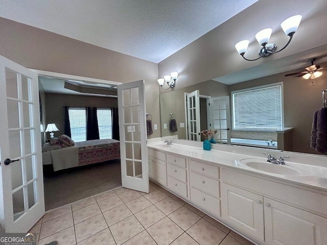 bathroom featuring vanity, ceiling fan, tile patterned floors, a textured ceiling, and french doors