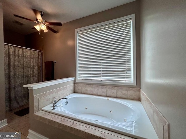 bathroom with ceiling fan, tile patterned flooring, and tiled tub