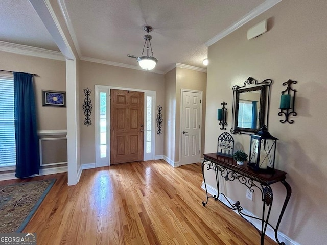 entrance foyer with light hardwood / wood-style flooring, crown molding, and a wealth of natural light