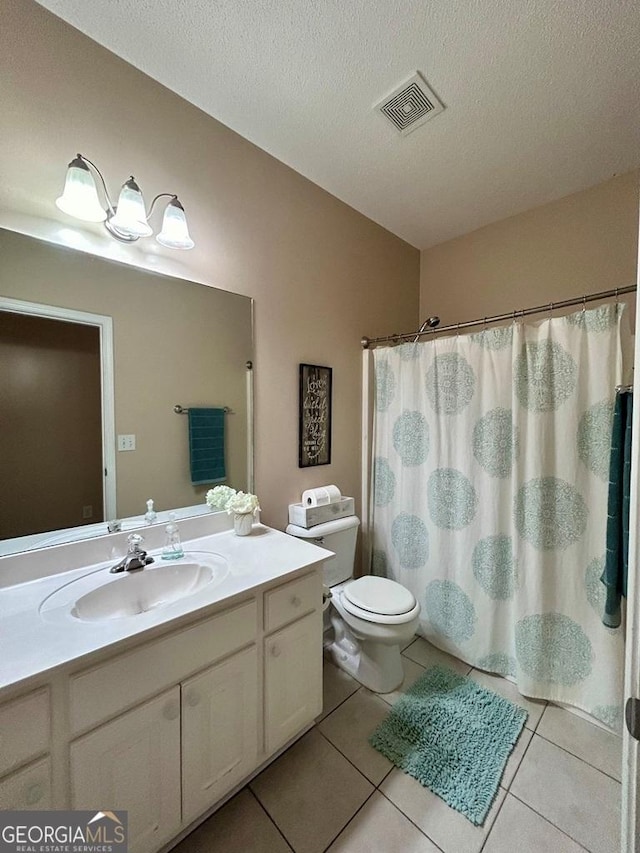 bathroom with tile patterned floors, toilet, a textured ceiling, vanity, and a shower with shower curtain