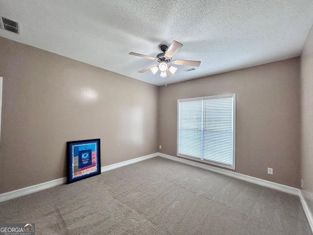 spare room with carpet flooring, a textured ceiling, and ceiling fan