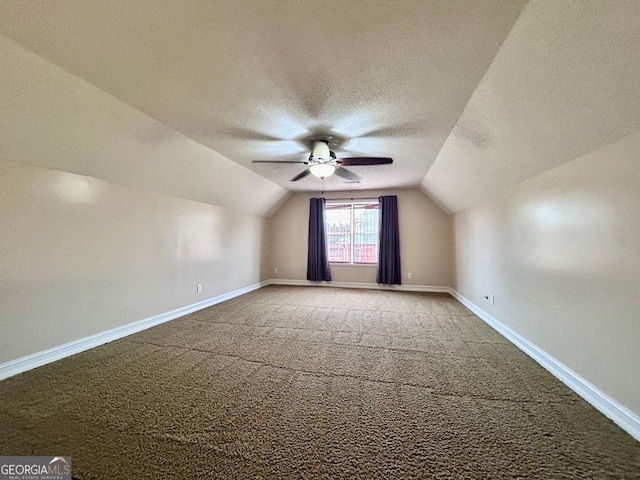 bonus room with lofted ceiling, ceiling fan, carpet floors, and a textured ceiling