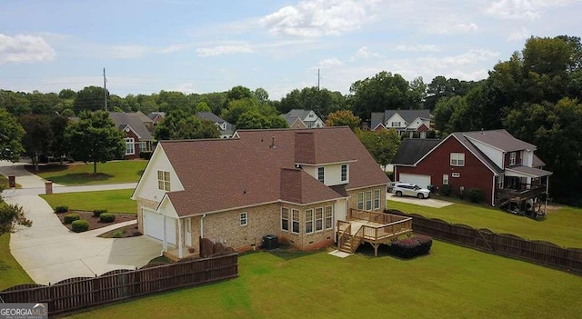 rear view of house with a wooden deck, a yard, and a garage