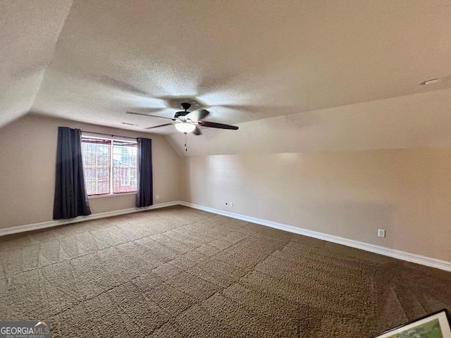 bonus room featuring ceiling fan, vaulted ceiling, a textured ceiling, and carpet flooring