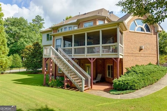 rear view of house with a sunroom and a yard