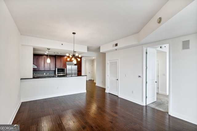 unfurnished living room with a chandelier and dark hardwood / wood-style flooring