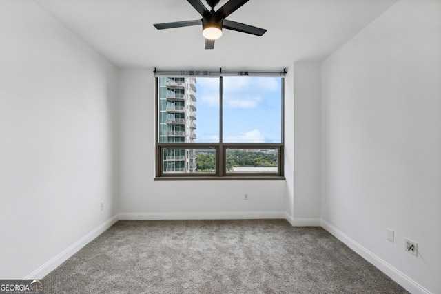 carpeted spare room featuring ceiling fan