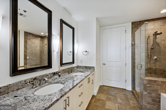 bathroom featuring tile patterned flooring, an enclosed shower, and vanity