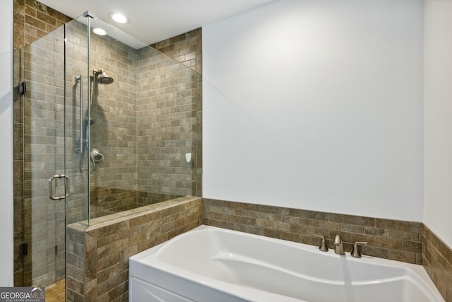 bathroom featuring independent shower and bath