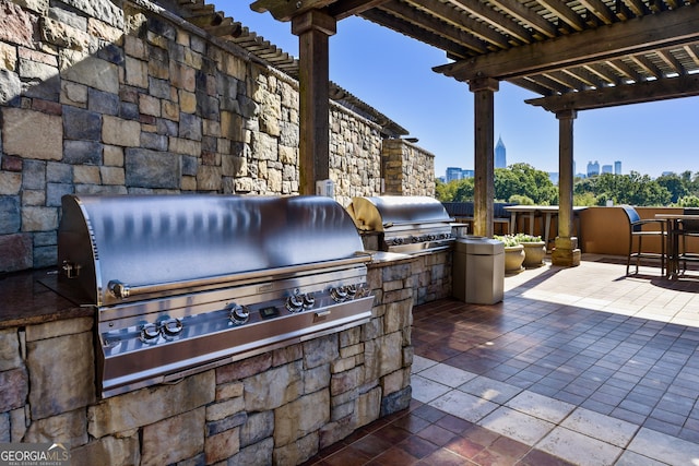 view of patio with area for grilling, an outdoor kitchen, and a pergola