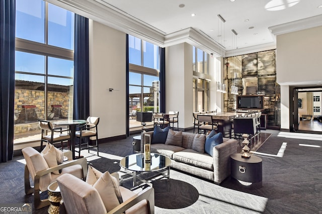 living room with a high ceiling, ornamental molding, and dark carpet