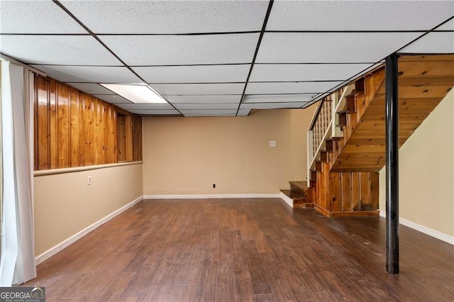 basement featuring dark wood-type flooring and a paneled ceiling