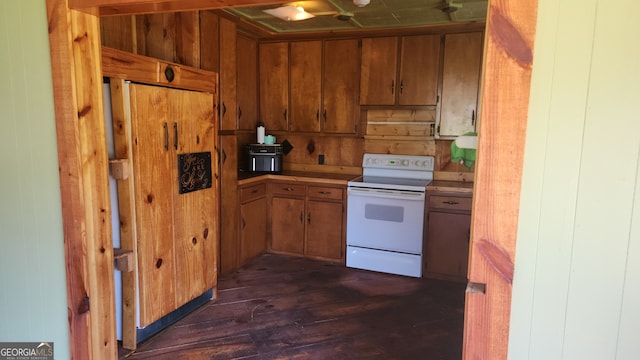 kitchen featuring wood walls, dark wood-type flooring, and electric range