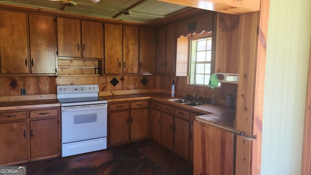 kitchen featuring electric stove, wood walls, and sink