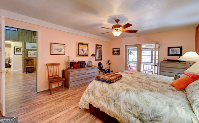 bedroom featuring a textured ceiling, access to outside, light hardwood / wood-style floors, and ceiling fan