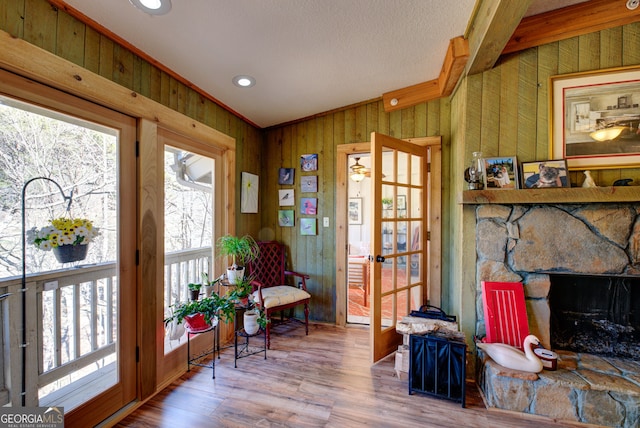 interior space featuring wood-type flooring, a fireplace, and wood walls